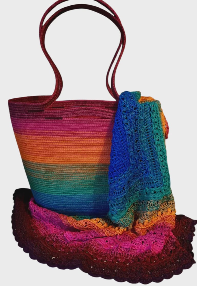 Rainbow gradient tote bag with knitted scarves in matching colors draped over it