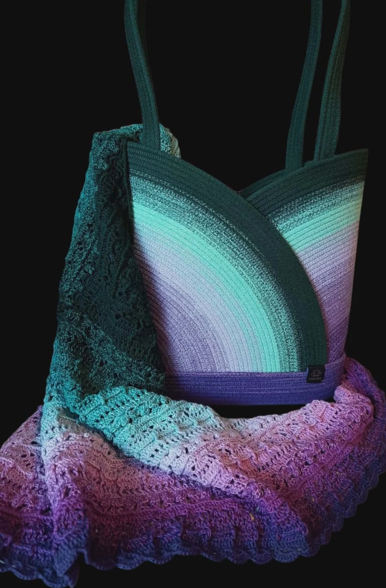 Handmade crochet tote bag featuring gradient stripes in turquoise, white, purple, and pink colors against black background
