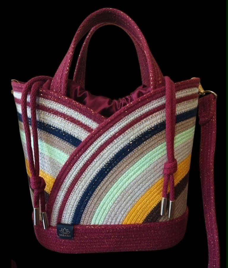 Burgundy tote bag with multicolored rainbow striped canvas panel and dual handles on black background
