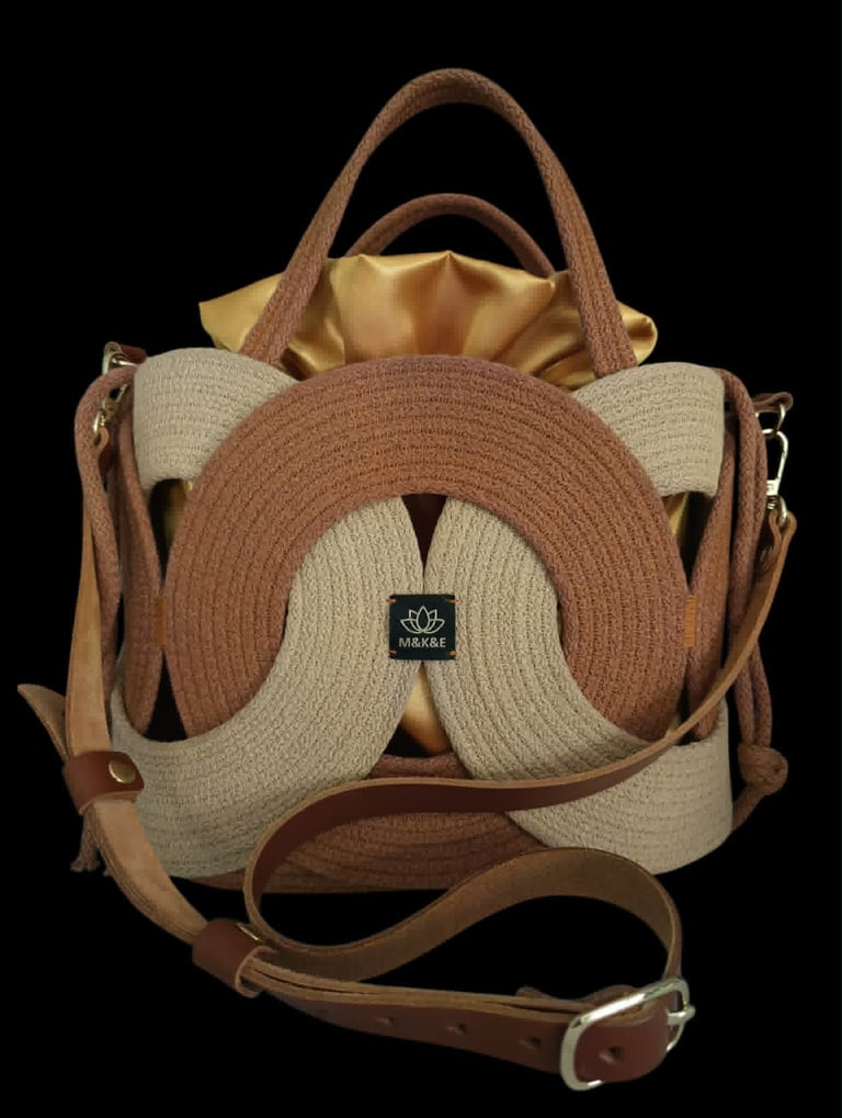 Beige and tan knit tote bag with dual handles and shoulder strap, featuring a decorative circular brown knit design in the center